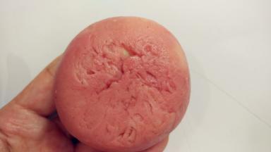 翻过来，将皮收一下，让它紧贴着馅料。一手大拇指按住馅料，另一手虎口往上推饼皮，使它紧贴着馅料并慢慢地往上爬，最后收口，收口一定要收紧。