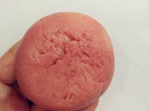 翻过来，将皮收一下，让它紧贴着馅料。一手大拇指按住馅料，另一手虎口往上推饼皮，使它紧贴着馅料并慢慢地往上爬，最后收口，收口一定要收紧。