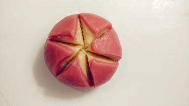 用一把锋利的小刀在面团上面平均地切上3刀，这样就有6道口子，切到椰蓉馅即可。