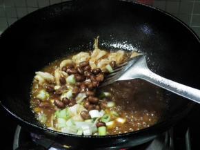 翻炒均匀，让虾仁均匀的裹上料汁后加入葱段和花生米。