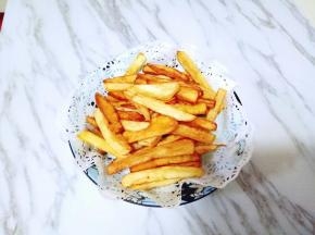 炸好的薯条放在油纸的盘子里，吸走多余的油份