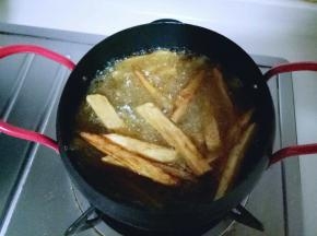 这时锅中油再次滚开，再加入炸锅一次的薯条。