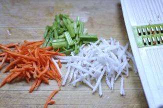 2、将需要用的菜都洗干净，白萝卜、胡萝卜分别擦丝，芹菜切断