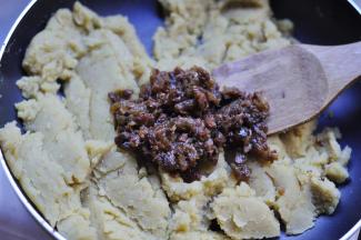 8、把切碎的葡萄干放到炒好的绿豆泥晾凉，