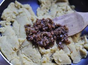 8、把切碎的葡萄干放到炒好的绿豆泥晾凉，