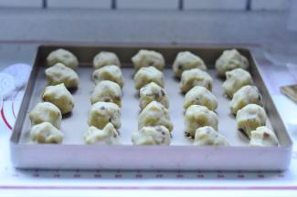 10、把揉好的绿豆泥面分成25个30克的面团，滚圆放入烤盘