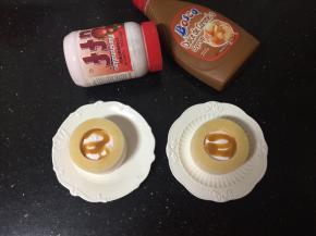 脱模后，逐个用小勺舀入草莓味Fluff 棉花糖，再淋入焦糖味巧克力酱，放上红提装饰一下即可。