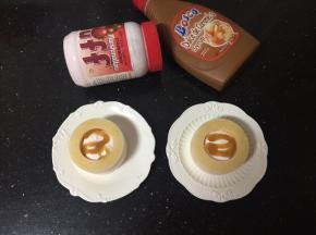 脱模后，逐个用小勺舀入草莓味Fluff 棉花糖，再淋入焦糖味巧克力酱，放上红提装饰一下即可。