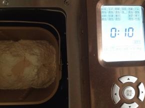 加入10克糖，21克蛋液，再放面粉，在面粉顶端放2克酵母。用东菱BM1352AE-3C面包机和面10分钟