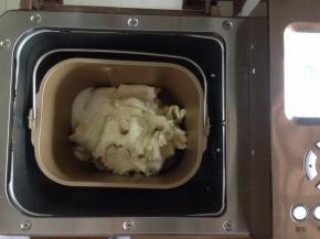 加入24克蛋液、42克糖、3.5克盐、18克奶粉和1.5克酵母，将面包桶放入面包机内，选择和面20分钟