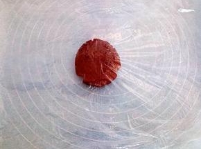 取一张和烤盘差不多大的油纸垫在下面（在准备1张油纸备用）取一块面团放在上面，盖一层保鲜膜