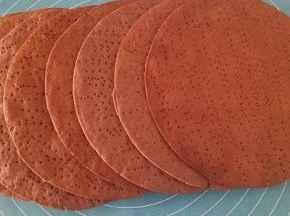 刚看出来的饼是软的，冷的就脆了，把四周的边角料掰下来用料理机打碎或者擀面杖擀碎，依次做好8个饼皮，可以在烤的时候擀下一个，这就是准备一张油纸的用处。另外准备着花生和核桃用料理机打碎备用