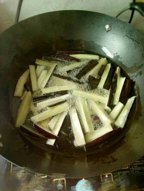 热锅倒油，烧至5成热，下长茄炸至表面微黄，捞出控油。