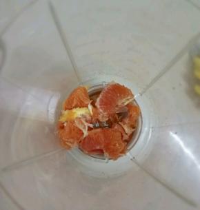 把雪橙去皮，分成小块，放入料理机中。