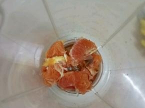 把雪橙去皮，分成小块，放入料理机中。