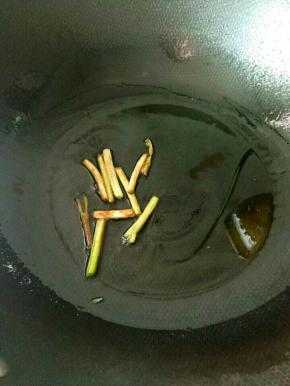 热锅凉油，下葱白煸成焦黄。