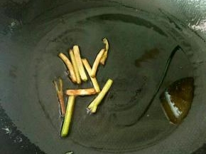 热锅凉油，下葱白煸成焦黄。