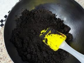 3．将融化后的黄油，倒入巧克力饼干末中进行混合。