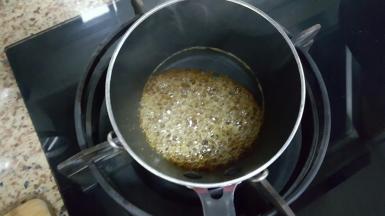 5．开始制作焦糖香蕉，砂糖放入奶锅中，加入水，中小火熬至呈淡褐色。