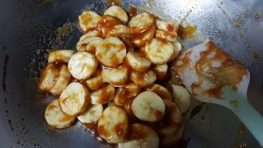 8．将香蕉切成厚一点的片，放在焦糖酱中使其包裹。