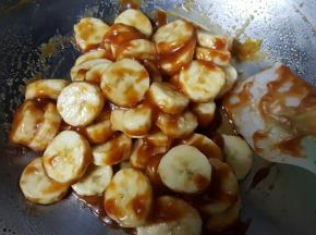 8．将香蕉切成厚一点的片，放在焦糖酱中使其包裹。