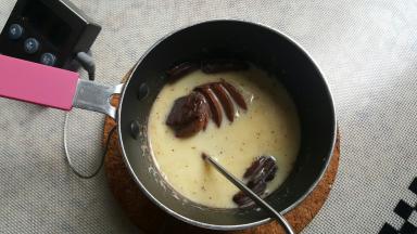 11．将淡奶油加热到微开，关火取下稍晾片刻后加入巧克力币进行混合（巧克力的融化温度在60度左右）。