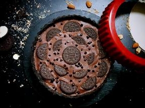 13．开始组合，将巧克力甘纳许倒在香蕉片上，奥力奥饼干斜插在上面，再撒上耐热巧克力豆，就完成了。放在冰箱中冷藏最好过夜。