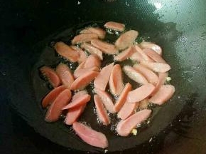 热锅凉油，下火腿肠中小火炒至微黄。