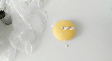 然后，白色圆面片，一切两半，做眼睛。并粘上黑色可可粉面团。