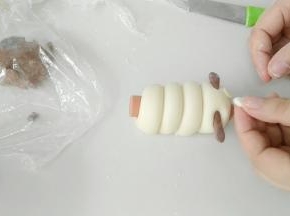 再粘上白色圆面片的眼睛，在粘点黑面团或者豆子之类的。