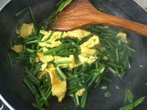 将韭菜和鸡蛋混合，鸡蛋用铲子切碎炒一分钟左右