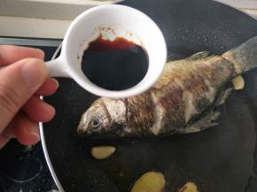 煎好的鲫鱼，倒入老抽。