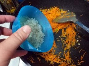 待胡萝卜丝变软，倒入粉条，炒匀；
