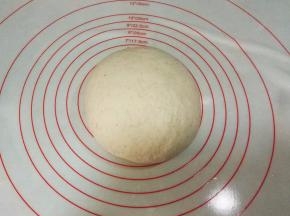 接下来做包子皮：先用少许水将酵母化开，倒入面粉中，加入清水，揉成光滑的面团，盖保鲜膜进行发酵。