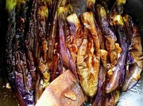 用木铲按压搅拌，确保每一个茄子都裹上酱汁，方便入味。