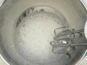 把蛋白和白醋倒入碗中，用打蛋器打出大气泡，加入一半的白糖。