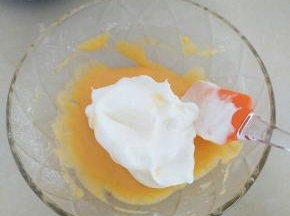 把蛋黄碗中，加入一半打好的蛋白，用刮刀上下拌匀。