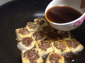 加入刚刚调好的汁沿着煎至金黄的豆腐倒