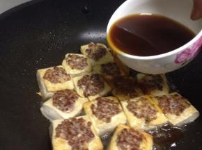 加入刚刚调好的汁沿着煎至金黄的豆腐倒
