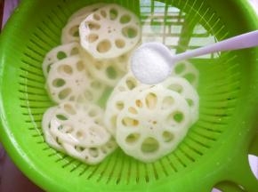 将切好薄片的莲藕放入器具中，冷水冲洗，再加入一勺盐，泡8分钟。