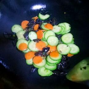 加入黄瓜，胡萝卜翻炒1分钟左右，加入盐、生抽翻炒