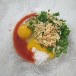  鸡蛋，香葱，虾皮加入碗中，加入1勺辣白菜的汤汁，再加入1小勺白糖。