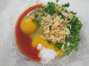  鸡蛋，香葱，虾皮加入碗中，加入1勺辣白菜的汤汁，再加入1小勺白糖。