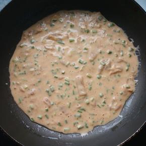 锅烧热，转小火，刷1小勺油，倒入面糊，轻轻晃动锅，使面糊平摊在锅中。