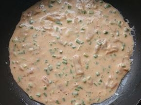 锅烧热，转小火，刷1小勺油，倒入面糊，轻轻晃动锅，使面糊平摊在锅中。