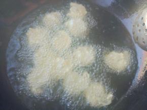 将虾仁一个个下入锅中，轻轻搅动，炸至八成熟