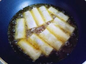 炸锅中放入食用油，油温8成时用筷子夹入包好的春卷。
