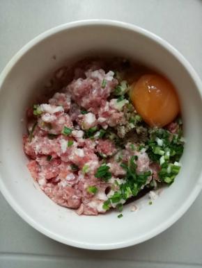 加入鸡蛋一个，料酒1茶匙，生抽2茶匙，水1茶匙，胡椒粉1小勺，顺着一个方向搅上劲