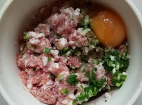 加入鸡蛋一个，料酒1茶匙，生抽2茶匙，水1茶匙，胡椒粉1小勺，顺着一个方向搅上劲