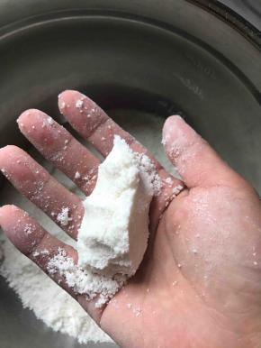 抓一把用手轻轻握紧，手松开时不易散开就差不多，如果手松开后立即散了，说明牛奶加的不够